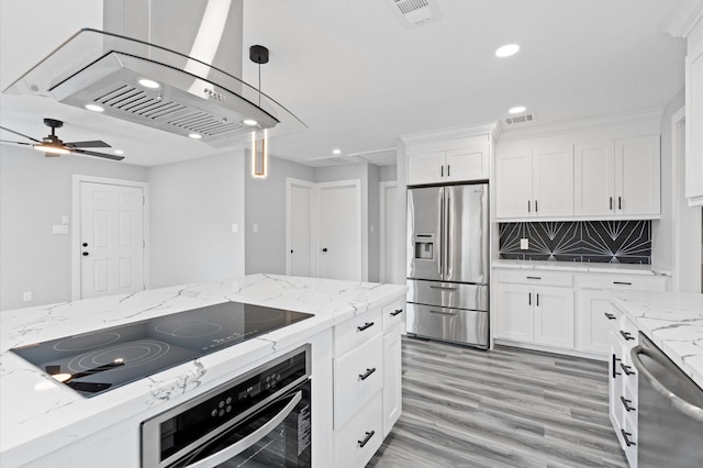 kitchen with white cabinetry, pendant lighting, black appliances, and light hardwood / wood-style flooring