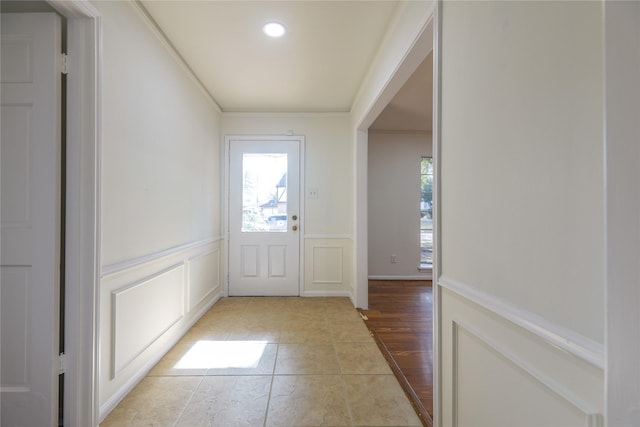 entryway with light hardwood / wood-style floors and crown molding