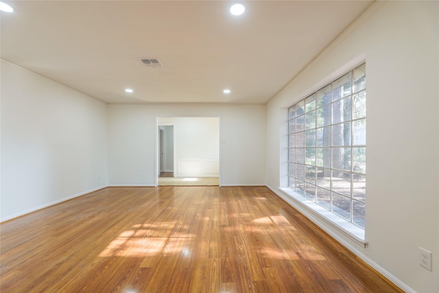 empty room featuring light hardwood / wood-style flooring and crown molding