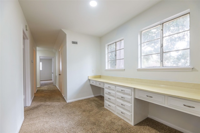 unfurnished office with built in desk and light colored carpet