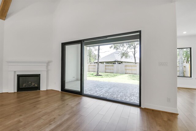 12926 Whitewater Way, Conroe, TX 77302 - unfurnished living room featuring wood finished floors, a glass covered fireplace, and recessed lighting