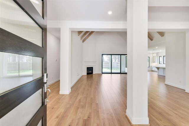 12926 Whitewater Way, Conroe, TX 77302 - unfurnished living room featuring light wood finished floors, a fireplace, beam ceiling, recessed lighting, and decorative columns
