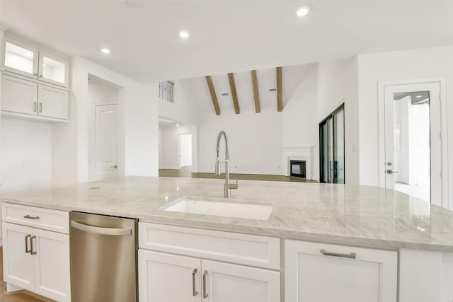 12926 Whitewater Way, Conroe, TX 77302 - kitchen with stainless steel dishwasher, open floor plan, white cabinets, light stone countertops, and a glass covered fireplace