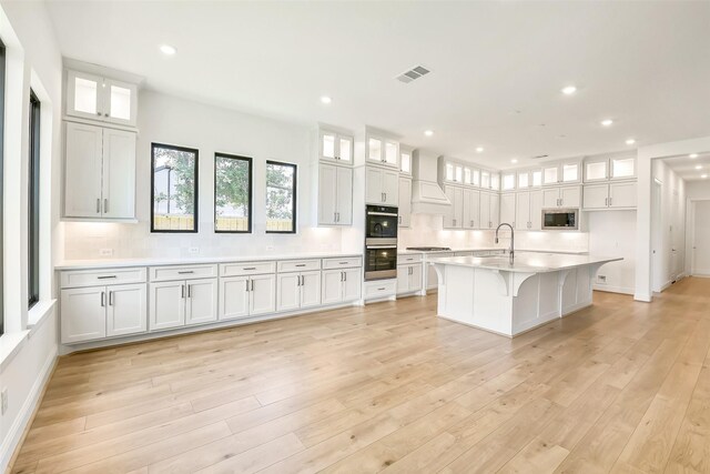 12926 Whitewater Way, Conroe, TX 77302 - kitchen with premium range hood, appliances with stainless steel finishes, decorative backsplash, white cabinetry, and recessed lighting
