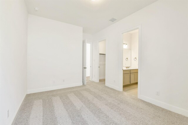 12926 Whitewater Way, Conroe, TX 77302 - unfurnished bedroom featuring light colored carpet, a spacious closet, ensuite bathroom, and a closet