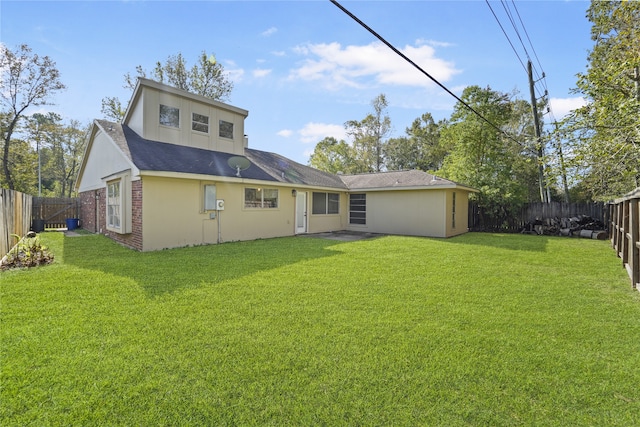 rear view of property featuring a lawn