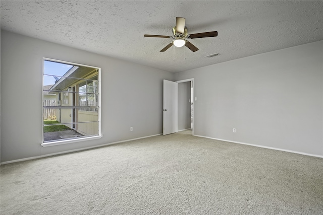 spare room featuring carpet, a textured ceiling, and ceiling fan