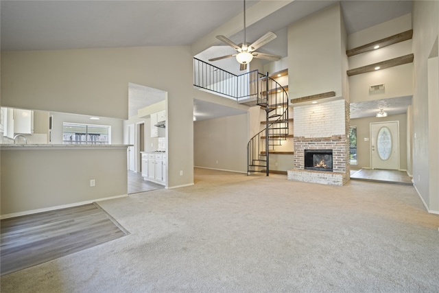 unfurnished living room featuring carpet flooring, ceiling fan, high vaulted ceiling, and a brick fireplace