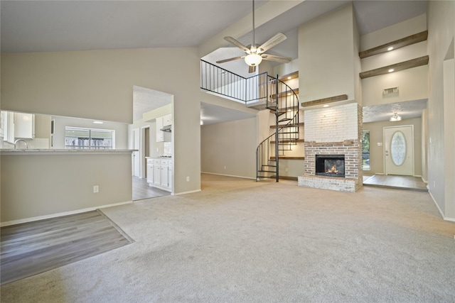 unfurnished living room featuring light colored carpet, a wealth of natural light, and high vaulted ceiling