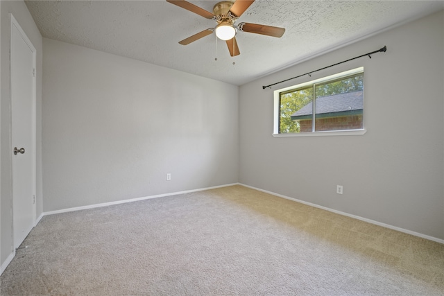 empty room featuring carpet flooring, ceiling fan, and a textured ceiling