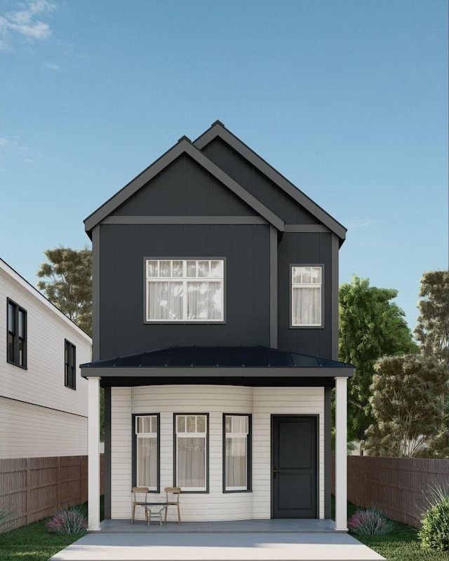 view of front of house featuring metal roof, a standing seam roof, and fence