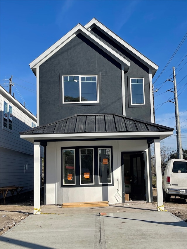 view of front of house featuring stucco siding, metal roof, and a standing seam roof