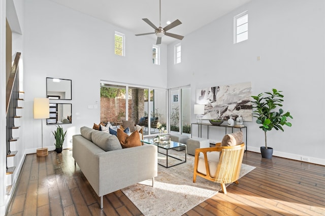 living room featuring a high ceiling, dark hardwood / wood-style floors, and ceiling fan