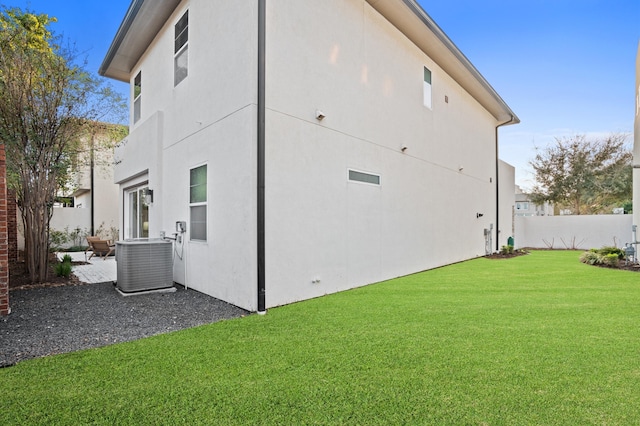 rear view of property featuring a yard, a patio, and central AC unit