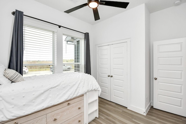 bedroom with ceiling fan, a closet, light wood-type flooring, and multiple windows