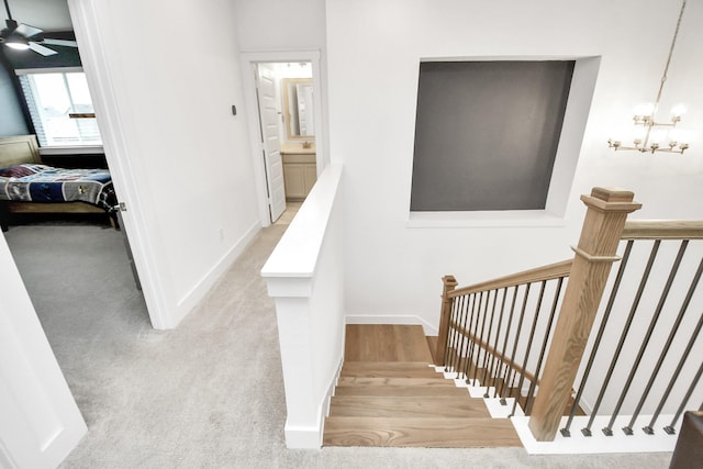 staircase with carpet flooring and a notable chandelier