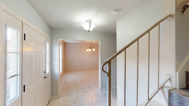 foyer with a chandelier and a textured ceiling