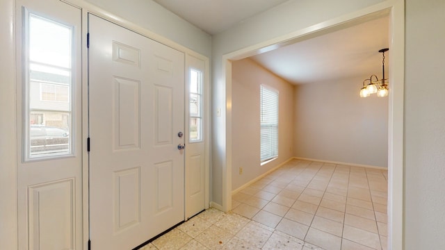 entryway featuring light tile patterned floors and a chandelier