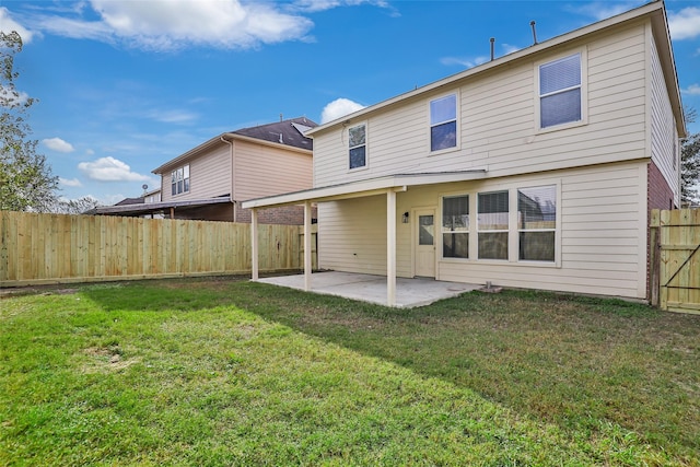 rear view of house with a yard and a patio