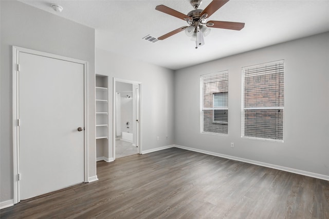 unfurnished bedroom featuring dark hardwood / wood-style flooring, ceiling fan, and ensuite bathroom