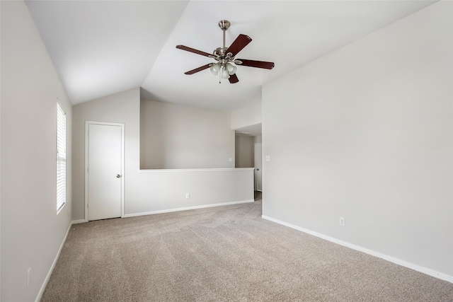 spare room with light carpet, vaulted ceiling, and ceiling fan