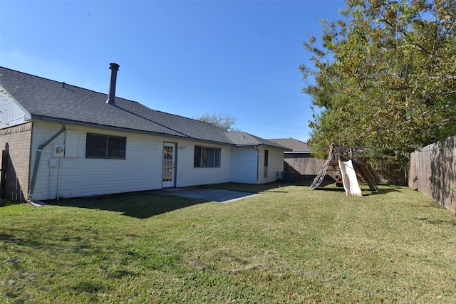 back of property with a lawn, a patio area, and a playground