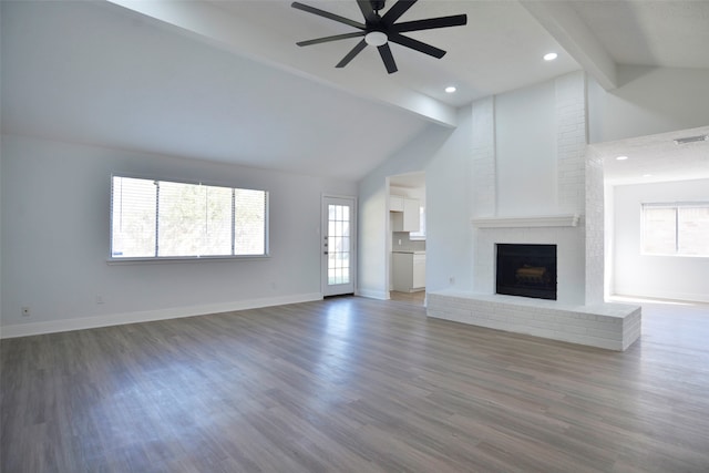 unfurnished living room with beamed ceiling, dark hardwood / wood-style floors, ceiling fan, and a wealth of natural light