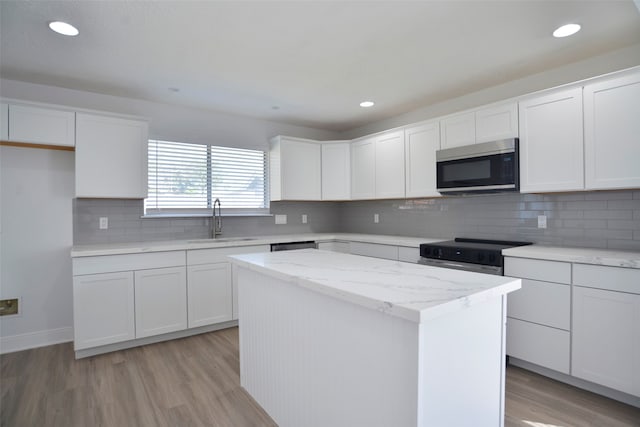 kitchen featuring a center island, white cabinets, sink, light hardwood / wood-style floors, and stainless steel appliances