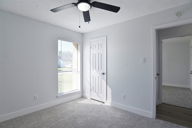 unfurnished bedroom with carpet, ceiling fan, and a textured ceiling