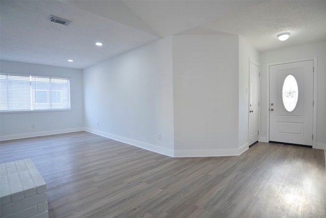 entrance foyer with hardwood / wood-style floors and a textured ceiling