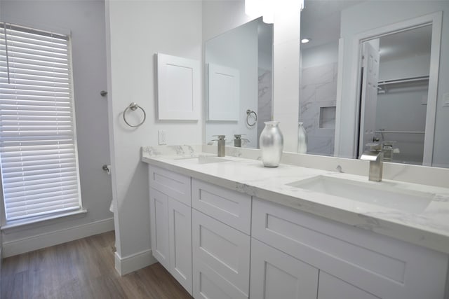 bathroom with a tile shower, vanity, and hardwood / wood-style flooring