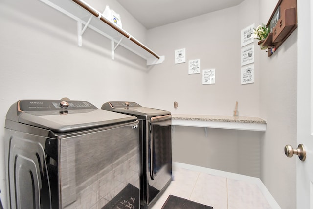 washroom featuring washing machine and dryer and light tile patterned flooring