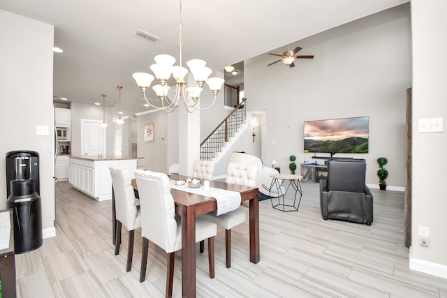 dining space featuring ceiling fan with notable chandelier and light wood-type flooring