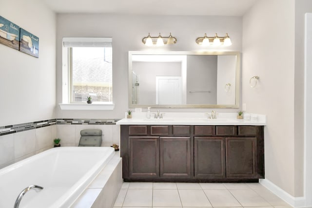 bathroom with tile patterned floors, vanity, and a relaxing tiled tub