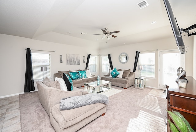 living room with a wealth of natural light, ceiling fan, and light tile patterned floors