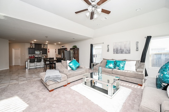 tiled living room with a wealth of natural light and ceiling fan