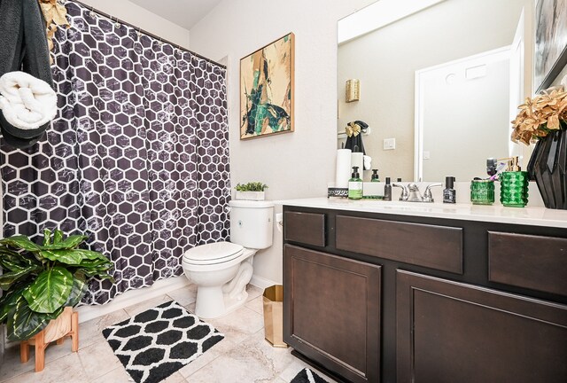 bathroom featuring tile patterned flooring, vanity, and toilet