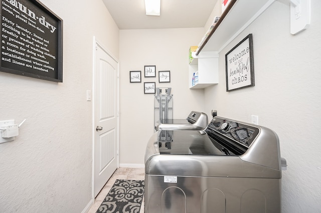 laundry room with light tile patterned flooring and washing machine and clothes dryer