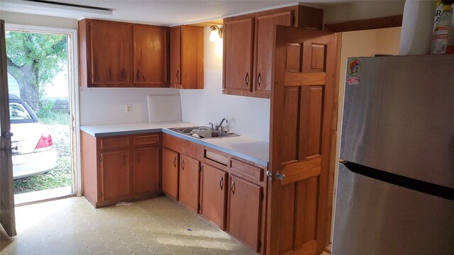 809 8th Ave N, Texas City, TX 77590 - kitchen featuring freestanding refrigerator, light countertops, brown cabinets, and light tile patterned floors