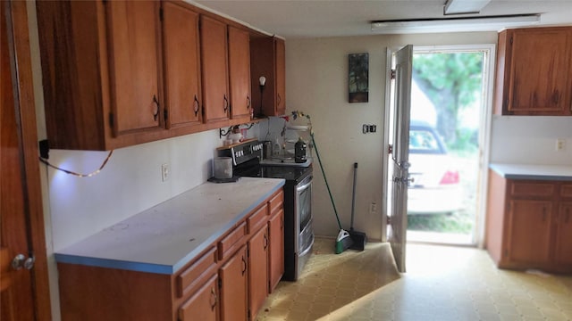 809 8th Ave N, Texas City, TX 77590 - kitchen featuring electric stove, brown cabinetry, and light countertops