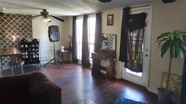 foyer with ceiling fan, dark wood-type flooring, a textured ceiling, and a baseboard heating unit