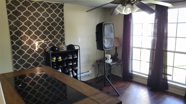 interior space with a baseboard radiator, plenty of natural light, dark wood-type flooring, and ceiling fan