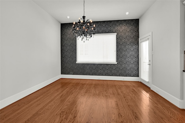 unfurnished dining area featuring hardwood / wood-style floors and a notable chandelier