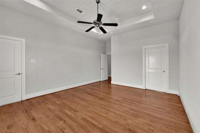 unfurnished bedroom with a raised ceiling, light hardwood / wood-style flooring, and ceiling fan