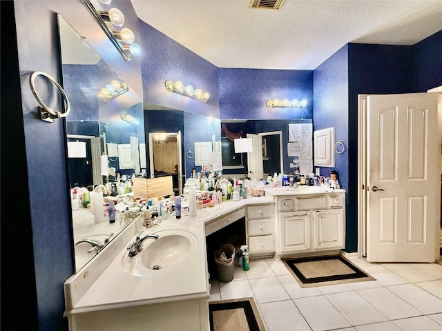 bathroom with tile patterned floors, vanity, and a textured ceiling