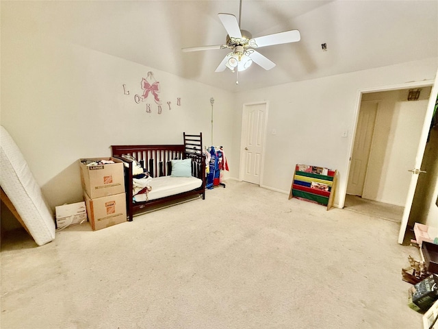 bedroom featuring carpet, ceiling fan, and a nursery area