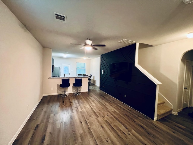 unfurnished living room with dark hardwood / wood-style floors, ceiling fan, and a textured ceiling