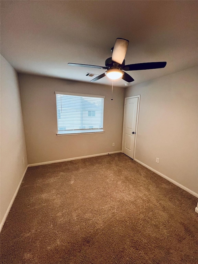 empty room featuring ceiling fan and carpet