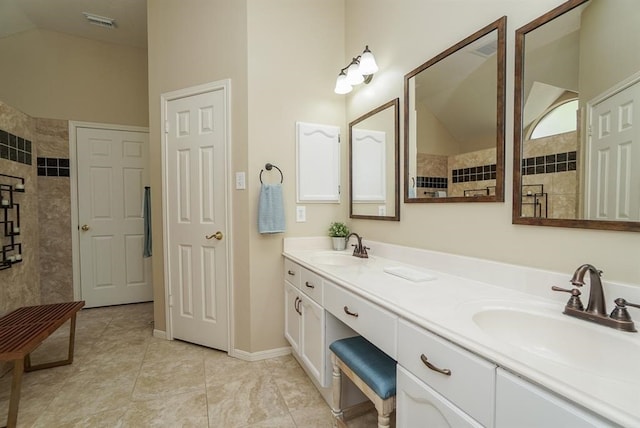 bathroom featuring tile patterned floors, vanity, tiled shower, and vaulted ceiling