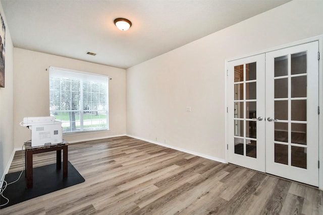 unfurnished room featuring french doors and wood-type flooring